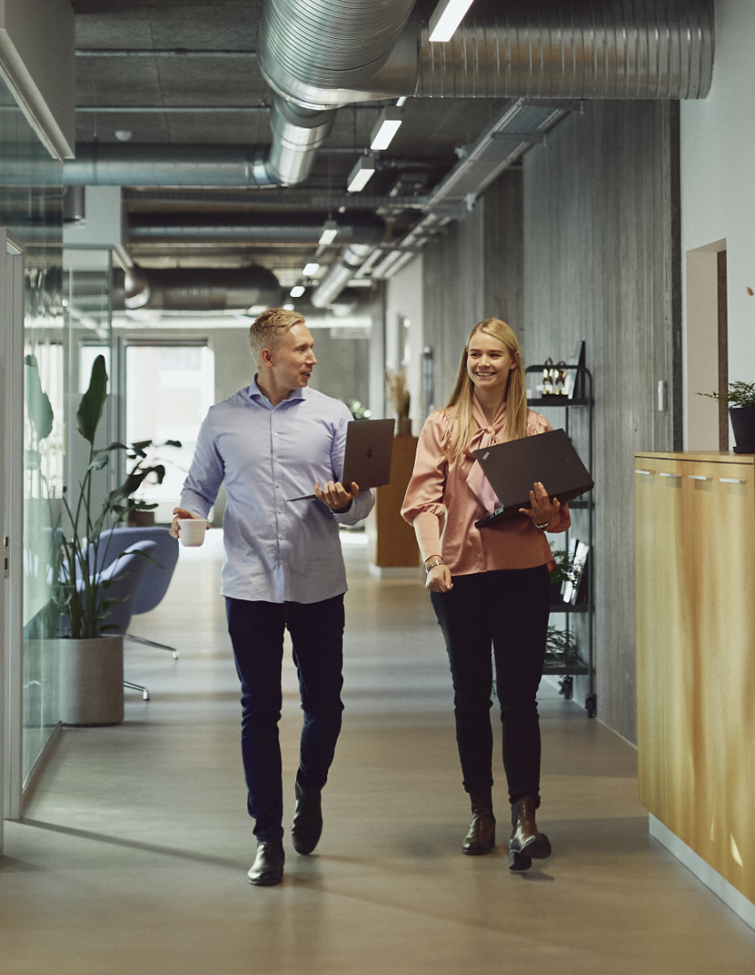 Two coworkers walking in the office